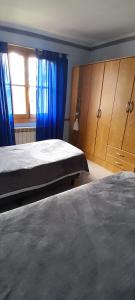 a bedroom with a bed and blue curtains at BetiUSH in Ushuaia