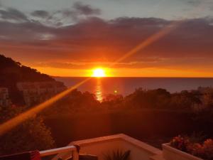 a sunset from the balcony of a condo at Apartamento con piscina - Tossa - Magníficas vistas al mar in Girona