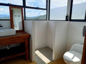 une salle de bain avec un lavabo et des toilettes et des fenêtres dans l'établissement Piscina-paisaje-calma y confort-Villa Luz de luna, à Santa Fe de Antioquia 54 autres photos