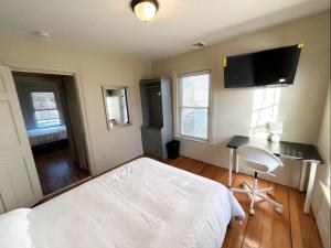 Un dormitorio con una cama, un escritorio y un televisor. en Nice cute bedroom in Lincoln with shared bathroom 3, en Lincoln 3 fotos más
