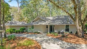 a house with a driveway and trees at Vicino al Mare in Hilton Head Island