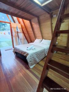 a bedroom with a bed in a wooden house at Cabañas Alpina in San Agustín