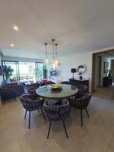 a dining room and living room with a table and chairs at LA ISLA RESIDENCES, DEPA DE LUJO, Acapulco Diamante in Acapulco