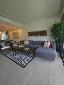 a living room with a blue couch and a rug at LA ISLA RESIDENCES, DEPA DE LUJO, Acapulco Diamante in Acapulco