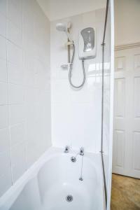 a bathroom with a bath tub with a shower at Fitzwilliam House -3 Bedrooms - Sleeps 5 in Redcar