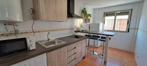 a small kitchen with a sink and a microwave at Edificio Primavera Viviendas turísticas in Calasparra +4 photos