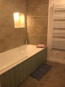 a bathroom with a bath tub with a mirror at Joli appart au cœur du village in Castillon-en-Couserans