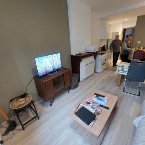 a living room with a tv and a table at résidence Les hortensias L4 in Bourbonne-les-Bains