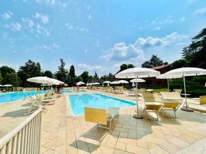 una piscina con sedie e ombrelloni di Flora Apt -100m dal Lago di Garda - Piscina a Sirmione