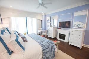 1 dormitorio con 1 cama, TV y vestidor en The Beach Club at Charleston Harbor Resort and Marina, en Charleston