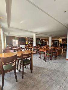 a dining room with wooden tables and chairs at Hotel Lunajuim in El Chalten