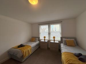 a bedroom with two beds and a window at Curwen Apartment - 2 Bedrooms - Sleeps 6 in Workington