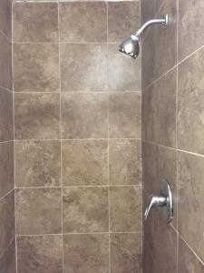 a shower with a glass door with a shower head at Roxy Hotel in Los Angeles