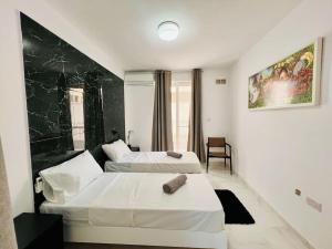 a hotel room with two beds and a chair at Beachfront Apartment Bugibba in St Paul's Bay