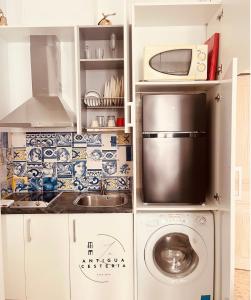 a kitchen with a microwave and a washer and dryer at Antigua Cestería in Seville