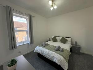 a bedroom with a bed and a window at Bolton Terrace - 2 Bedrooms - Sleeps 4 in Workington