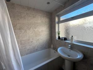 a bathroom with a sink and a bath tub and a window at Bolton Terrace - 2 Bedrooms - Sleeps 4 in Workington