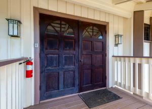 a wooden door of a house with a fire extinguisher at Paniolo 210B in Princeville +37 photos