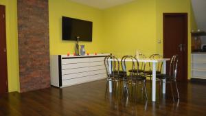 a dining room with yellow walls and a table and chairs at Penzión Melódia in Kanianka