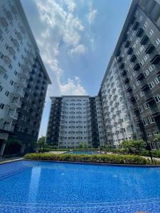 CaintaにあるMG Place -2 BR condo unit at SMDC Charm Residences, Cainta, Rizal, 1900のスイミングプール付きの2棟の大きなアパートメントです。