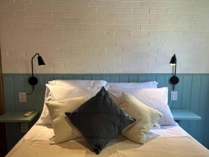 a black umbrella sitting on a bed with pillows at Oka Káa - Bosque da Praia Pipa Flat 33 in Pipa +33 photos