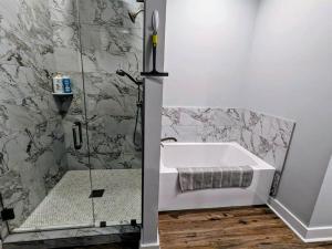 a bathroom with a shower and a bath tub at Tegarden Cottage at Gulfport Beach in Gulfport +19 photos
