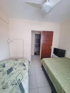 a bedroom with two beds and a television in it at Apto perfeito em Arraial do Cabo - Prainha in Arraial do Cabo