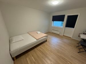 Un dormitorio con una cama y un escritorio y dos ventanas. en City Apartments - Stavanger, en Stavanger
