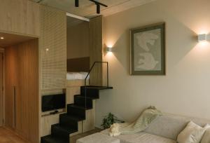 Una sala de estar con una escalera y un sofá. en Mutuo Vive, en Guadalajara
