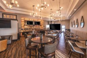 a restaurant with tables and chairs and a bar at Delta Hotels by Marriott Detroit Novi in Farmington Hills
