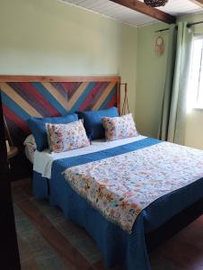 una camera da letto con un letto con lenzuola e cuscini blu di Viudita del Diablo a Punta Del Diablo