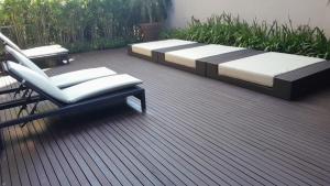a patio with two beds and two chairs at Studio LUA home Batel - Luxo e Conforto no coração de Curitiba! in Curitiba