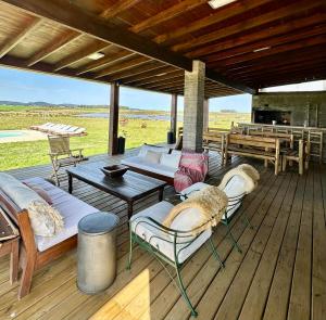 a deck with couches and a table and chairs at Chacra para 13! A 20min Punta del Este - Starlink in Maldonado