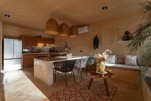 a kitchen with a table and a counter in a room at Casa Ingo Sisal in Sisal