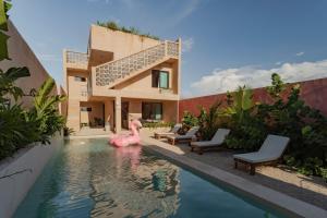 a pool with a pink flamingo in front of a house at Casa Ingo Sisal in Sisal