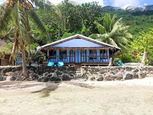 a villa on the beach with palm trees at Te Nahe Toetoe - New Look 2025 in Parea