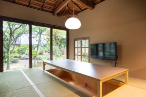 a wooden table in a room with a tv and a table at n estate Kyoto-Arashiyama in Shimo saga +56 photos