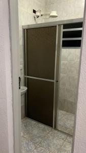 a glass shower door in a bathroom with a toilet at Linda Chácara com Piscina Churrasqueira e Wi-FI in Mairinque