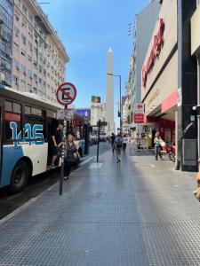 a sidewalk in a city with a bus at Obelisco Haus in Buenos Aires