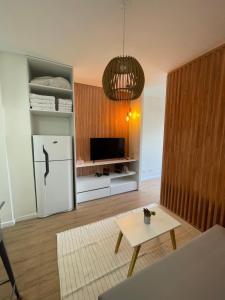 a living room with a white refrigerator and a table at Obelisco Haus in Buenos Aires