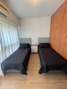 a bedroom with two beds and a window at Obelisco Haus in Buenos Aires
