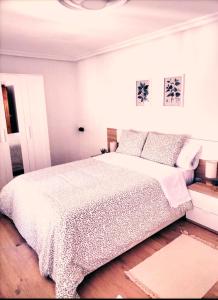 een witte slaapkamer met een groot bed met witte lakens en kussens bij La casina Redes -Tlf 67964 nueve cero tres uno in Villamorey +24 foto's