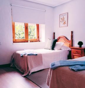 een slaapkamer met twee bedden en een raam bij La casina Redes -Tlf 67964 nueve cero tres uno in Villamorey