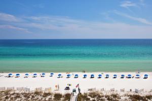 una playa con sillas y sombrillas y el océano en Holiday Inn Express Pensacola Beach, an IHG Hotel, en Pensacola Beach