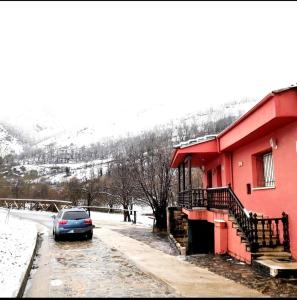 een auto geparkeerd voor een rood gebouw bij La casina Redes -Tlf 67964 nueve cero tres uno in Villamorey