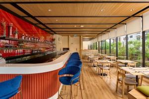 a restaurant with blue chairs and tables and windows at MO Hotel Bangkok in Bangkok