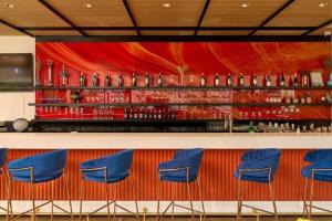 a bar with blue chairs against a red wall at MO Hotel Bangkok in Bangkok +21 photos