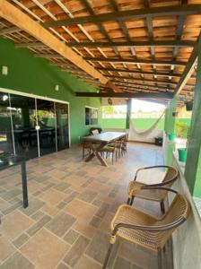 a room with chairs and a table in a room with green walls at Casa perto da lagoa - Balneário São Pedro in São Pedro da Aldeia