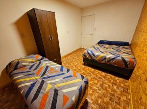 a bedroom with two beds and a dresser at Atardeceres Mágicos in Tolhuin