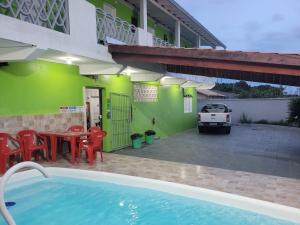 イタニャエンにあるUnidades 1 e 2 e 3 Pousada do Sossego Mar e Verdeのプール、テーブル、椅子付